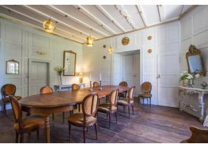SersにあるChâteau de Sersの大きな木製テーブルと椅子が備わる広い客室です。