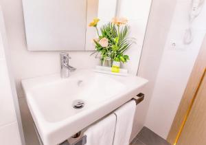 un lavabo con un jarrón de flores. en Hotel Playas de Paguera, en Paguera 42 fotos más