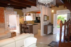 a living room with a white couch and a kitchen at Maison de vacance 2 Chambres à 200m de la plage in Sainte-Anne
