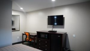 ein Schlafzimmer mit einem Bett und einer Kommode mit einem Fernseher in der Unterkunft Best Way Inn in Middlefield