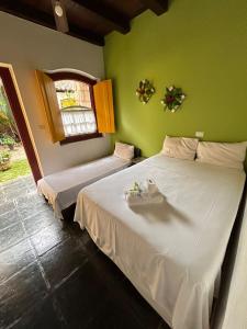 two beds in a room with green walls at Pousada Solar do Algarve in Paraty