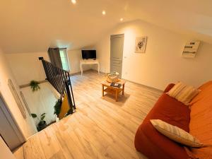 ein Wohnzimmer mit Sofa und Fernseher in der Unterkunft Charmante MAISON avec JARDIN & PARKING, tout équipé et confort - 10 min à pied de la mer in Criel-sur-Mer + 6 Fotos