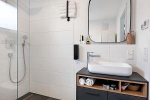 Willkommen in Ihrem Luxus-Penthouse في Ziegelhausen: حمام أبيض مع حوض ومرآة +25 صورة