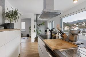 Willkommen in Ihrem Luxus-Penthouse في Ziegelhausen: مطبخ مع كونتر مع لوح تقطيع على الموقد