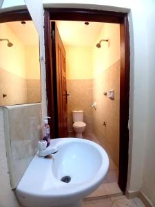 Un baño con lavabo blanco y inodoro. en Escaped Diani, en Diani Beach 8 fotos más