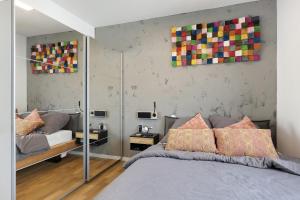 Willkommen in Ihrem Luxus-Penthouse في Ziegelhausen: غرفة نوم بسرير وجدار به لوحات