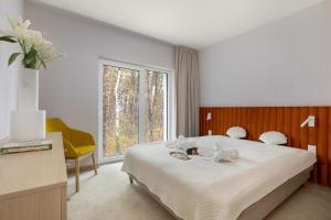 a bedroom with a bed and a large window at Apartamenty Joy Me Łukęcin in Łukęcin +55 photos