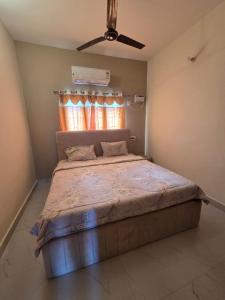 ein Schlafzimmer mit einem großen Bett und einem Deckenventilator in der Unterkunft Lago Luxe Inn in Chennai