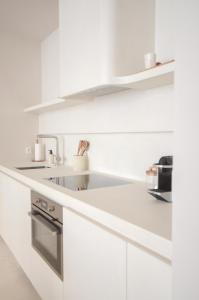 a kitchen with white cabinets and a sink at Luxurious 1BR Apartment with Parking in Antwerp