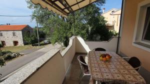 a table on a balcony with fruit on it at Apartment Malinska, Primorje-Gorski Kotar 20 in Sveti Vid-Miholjice