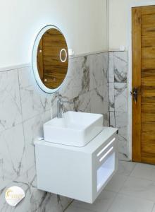 a white bathroom with a sink and a mirror at Maison moderne et spacieuse 9 min Ivato aeroport  +15 photos