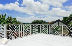 a balcony with a white fence and trees at Maison moderne et spacieuse 9 min Ivato aeroport 