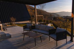 a couch and two chairs on a patio at Twin Vista A-Frame Cabins in Sovata