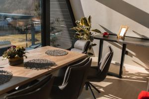 a table and chairs in a room with a window at Twin Vista A-Frame Cabins in Sovata
