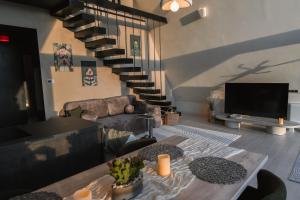 a living room with a tv and a couch and a table at Twin Vista A-Frame Cabins in Sovata