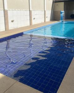 a swimming pool with blue tiles on the water at Flat 01 Quarto e sala novo na rua dos Girassóis em Bonito-PE in Bonito +6 photos