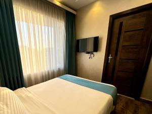a bedroom with a bed and a window and a door at Gabry Pyramids And Grand Egyptian Museum View Hotel in Cairo