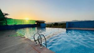 a large swimming pool with a metal pool noodle in the water at S K Pushkar Resort in Pushkar