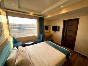 een hotelkamer met een bed en een raam bij Gabry Pyramids And Grand Egyptian Museum View Hotel in Caïro