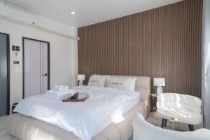 ウタイターニーにあるฌอณบูติค Shon Boutiqueの大きな白いベッドと椅子のある寝室