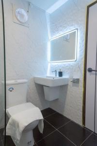 a white bathroom with a toilet and a sink at ฌอณบูติค Shon Boutique in Ban Nong Nam Khan