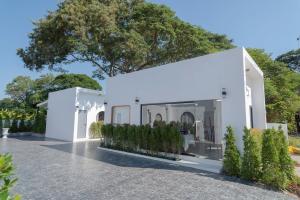 a white house with plants in front of it at ฌอณบูติค Shon Boutique in Ban Nong Nam Khan
