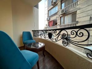 a balcony with two chairs and a table and a building at Gabry Pyramids And Grand Egyptian Museum View Hotel in Cairo