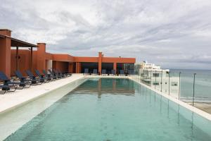 Faranda Collection Cartagena, a member of Radisson Individuals في كارتاهينا دي اندياس: حمام سباحة في مبنى مع كراسي والمحيط