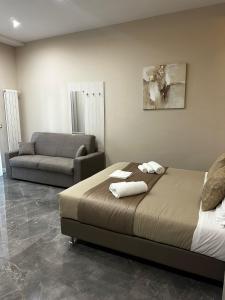 un dormitorio con una cama y un sofá en DEDA & FOVE, en Nápoles