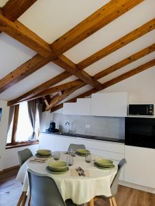 Appartamento Vittoria في كليس: غرفة طعام مع طاولة عليها لوحات