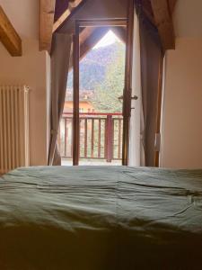 Appartamento Vittoria في كليس: غرفة نوم بها سرير ونافذة كبيرة