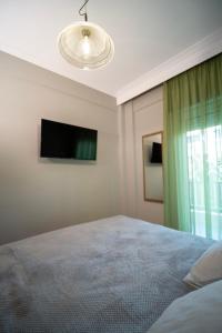 a bedroom with a bed and a flat screen tv at Casa Aphrodite Thessaloniki in Thessaloniki
