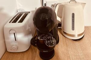 a coffee maker next to a toaster and a blender at Réveil face à la mer - Plage à 2 min - Résidence calme in Gourbeyre