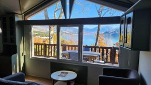 ein Zimmer mit einem großen Fenster mit Blick auf einen See in der Unterkunft La perle du lac - Némausa location in Chorges