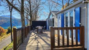 eine Veranda eines Hauses mit einem Holzzaun in der Unterkunft La perle du lac - Némausa location in Chorges + 34 Fotos