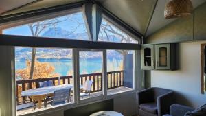 ein Zimmer mit einem großen Fenster mit Blick auf einen See in der Unterkunft La perle du lac - Némausa location in Chorges