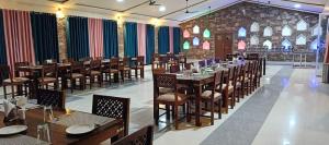 a restaurant with tables and chairs in a room at S K Pushkar Resort in Pushkar