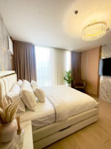 a bedroom with a large white bed with a chandelier at Modern 1 bedroom spacious apartment with Venice Grand Canal View in Manila +10 photos