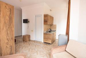 a kitchen with a couch and a sink in a room at Batumi Inn Hotel in Batumi