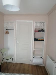 a closet with a white door and a chair at Maison- studio- 2 étoiles in Pluduno