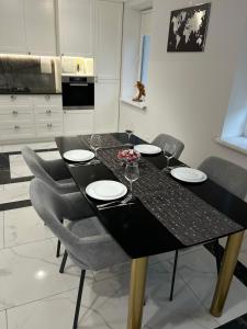 CăuşeniにあるApartament modernのダイニングテーブル(椅子4脚、黒いテーブル付) +8枚の写真
