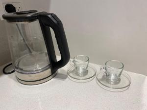 a black coffee pot and two glasses on a counter at סוויטת האחד והיחידה in Or ‘Aqīvāh