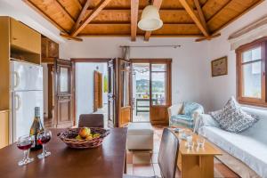 a living room with a couch and a table with wine glasses at Μeropi & Natalia Villas in Skopelos Town