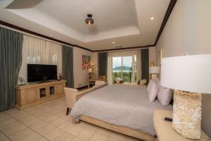 a bedroom with a large bed and a television at Vista Bahia 3C - 3bdr 3 bath ocean View in La Mona +37 photos