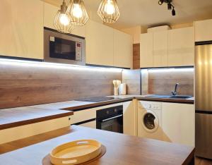 a kitchen with white cabinets and a washer and dryer at Apartamento Cumbre Loba in La Pinilla