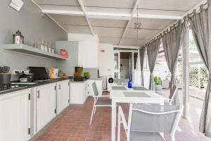 eine Küche mit weißen Schränken und einem Tisch und Stühlen in der Unterkunft La Casa del Viaggiatore in Milazzo