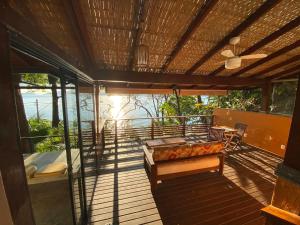 a balcony with two beds and a table and chairs at Casas do Mar in Ilhabela