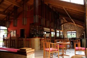 a dining room with wooden chairs and a bar at Le Jardin du Roy in Ranohira