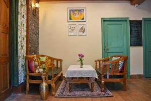 a room with a table and two chairs and a green door at Arcelia Cottage, Cozy Villa in Nainital in Nainital