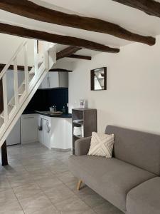 a living room with a couch and a kitchen at Logement cosy en plein centre de Joigny 2 à 3 pers - Cosy 4 in Joigny +6 photos
